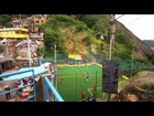 RIO DE JANEIRO, BRAZIL - JUNE 23: Tracking shot of soccer game to scenic view of a favela